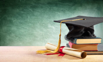 Graduation Cap And Diploma On Table With Books